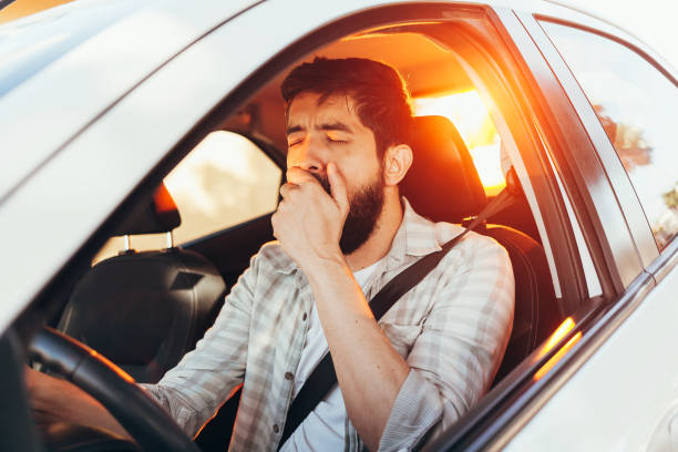 Tired man yawning while driving his car Tired man yawning while driving his car tired stock pictures, royalty-free photos & images