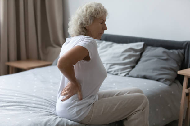 cansado molesto anciana se siente fuerte backpain inferior - back pain when sleeping fotografías e imágenes de stock