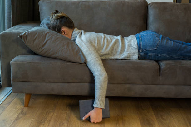 ソファの上の疲れ女性睡眠 - ng ストックフォトと画像