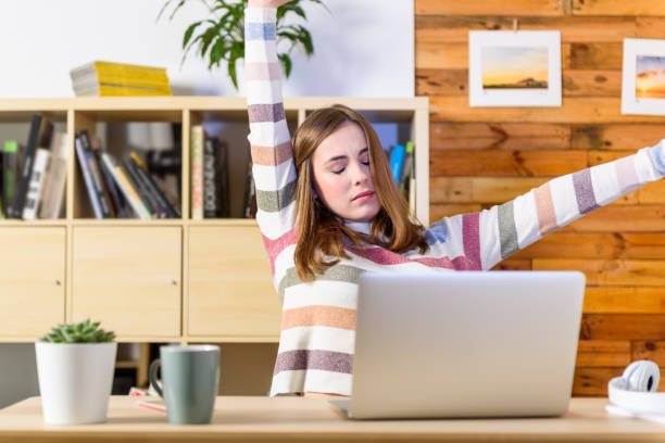 Tired woman working on desk stock photo