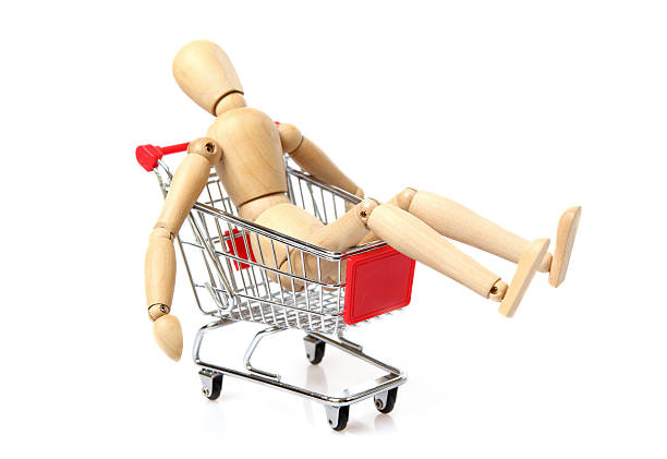 Tired Wood Man in a shopping cart stock photo