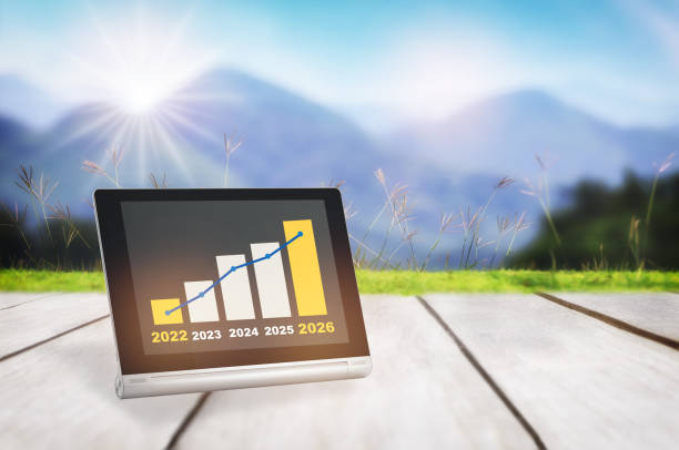 2022 to 2026 sustainable business strategy and financial growth graph stock trading on computer digital tablet on plank and mountain background stock photo
