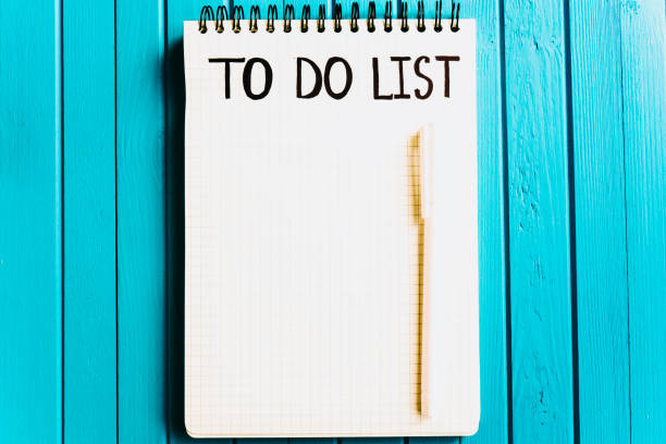 To do list inscription on a blank sheet of a notebook with a pen on a turquoise wooden background, copy space. List of important things to do on a clean paper stock photo