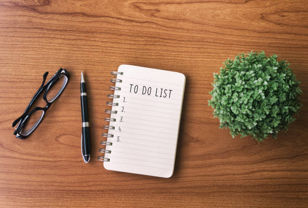 To Do List Text on Notepad Directly above view of office desk with Notepad and text - To do list. to do list stock pictures, royalty-free photos & images