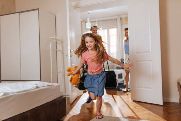 To the beach! Shot of a happy family entering their accomodation hotel stock pictures, royalty-free photos & images