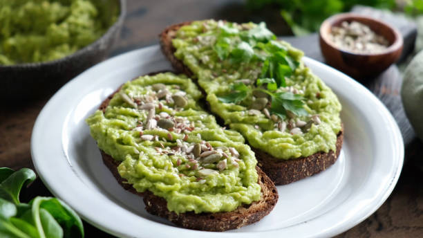 Toast with mashed avocado and seeds stock photo