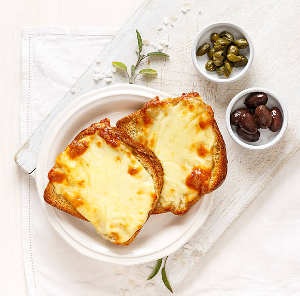 Toasted bread with cheese on a white plate stock photo