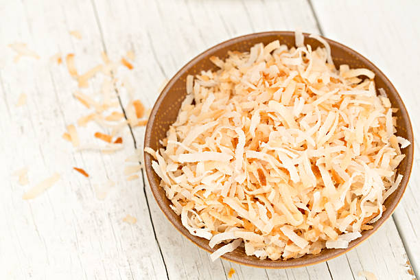 Toasted Coconut An overhead close up shot of a bowl full of shredded and toasted coconut. toasted food stock pictures, royalty-free photos & images
