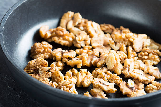 Toasting Walnuts. Walnuts in pan for toasting toasted food stock pictures, royalty-free photos & images