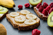 Sweet delicious gluten free toasts with ripe raspberries, bananas and kiwi