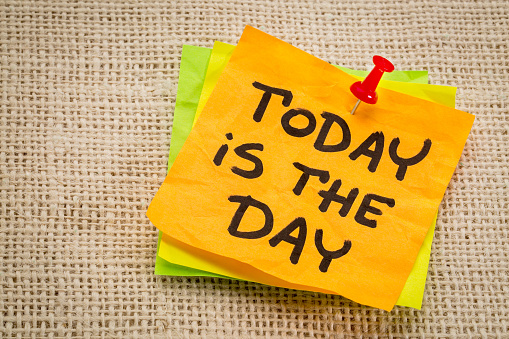 today is the day reminder on a sticky note against burlap canvas