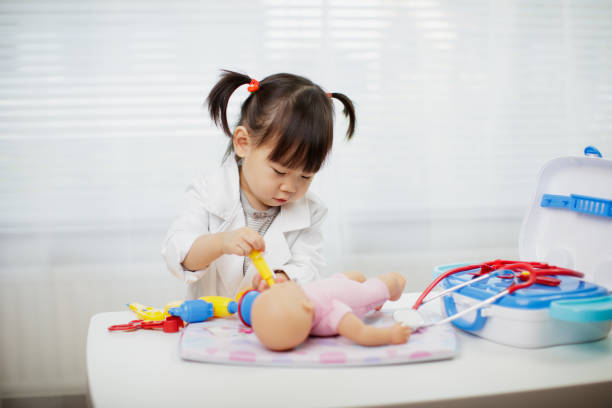 Toddler baby girl pretend playing as doctor at home Toddler baby girl pretend playing as doctor at home dressing up stock pictures, royalty-free photos & images