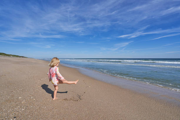 Toddler Girl Playing on the Beautiful Playlinda Beach in the Canaveral National Seashore along the  Atlantic Ocean Near Merritt Island National Wildlife Refuge Florida stock photo