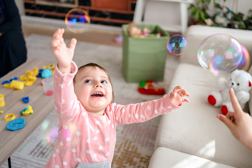 Toddler girl playing with soap bubbles