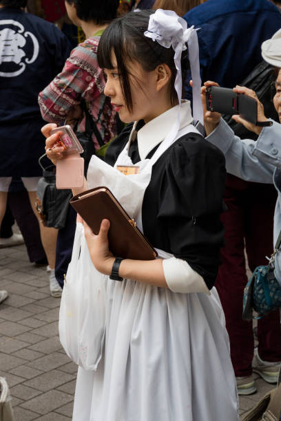 Tokyo, Japan - Cosplay girl as a maid in the street Tokyo, Japan - May 14,2017: Anime cosplay teenage girl as a maid in the street with her mobile phone french maid outfit stock pictures, royalty-free photos & images