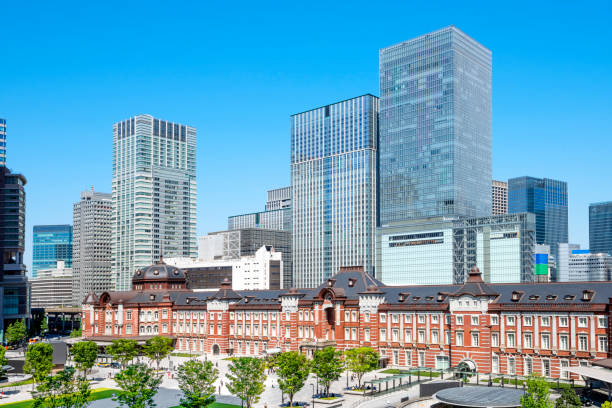 東京駅と晴天の高層ビル - 丸の内ビジネス地区、東京、日本。 - 東京駅 ストックフォトと画像