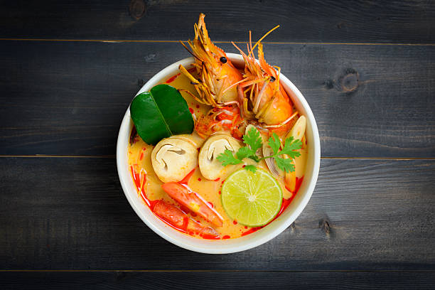 Tom Yum Soup Tom Yum Soup or River Prawn Spicy Sour Soup (Tom Yum Goong) on wooden table top view, Thai local food tom yum soup stock pictures, royalty-free photos & images