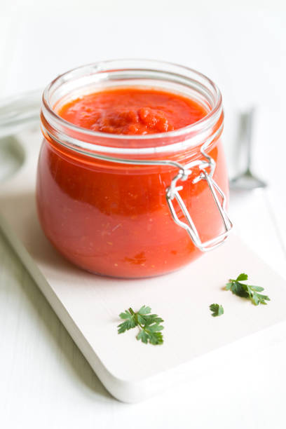 Tomato Sauce In Jar On White Wooden Table stock photo