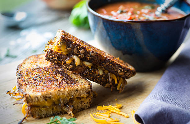 Tomato Soup with Grilled Cheese Fresh tomato soup with grilled onion and cheese sandwich comfort food stock pictures, royalty-free photos & images