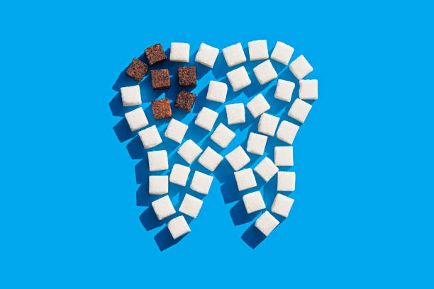 Tooth of sugar cubes Tooth of sugar cubes on blue background dental cavity stock pictures, royalty-free photos & images