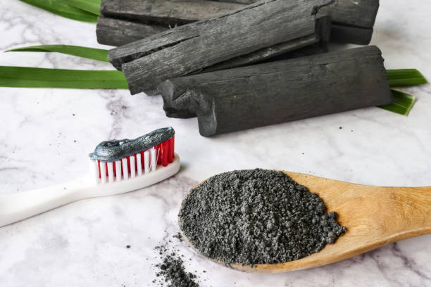 Toothpaste by activated charcoal powder on marble table Toothpaste by activated charcoal powder on marble table coal stock pictures, royalty-free photos & images