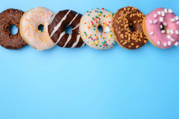 Top above overhead closeup flat lay flatlay view photo of yummy style lot donuts lying in a row isolated over blue pop pastel background Top above overhead closeup flat lay flatlay view photo of yummy style lot donuts lying in a row isolated over blue pop pastel background doughnut stock pictures, royalty-free photos & images