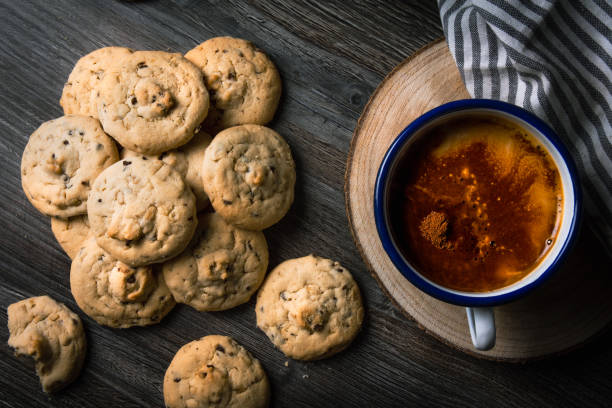 Top down view on chocolate chip cookies and coffee on a dark wooden table. stock photo