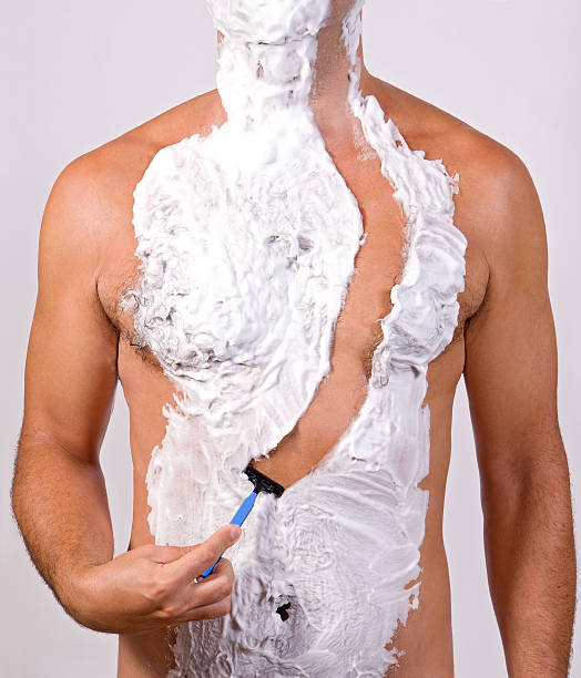 Top half of unshaven male body covered in shaving foam stock photo
