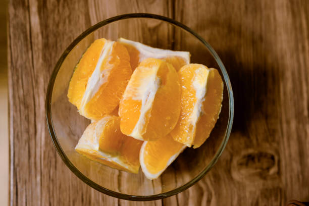 top shot of sliced orange fruit on wooden table stock photo