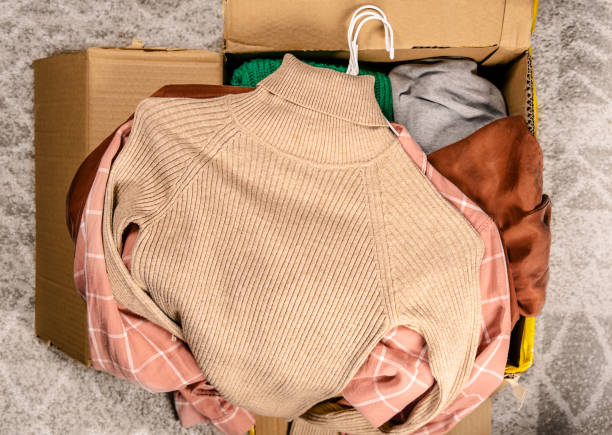Top view at clothes in cardboard box Clothes for clothing swap. Concept of waste problem in fashion industry. thrift store stock pictures, royalty-free photos & images