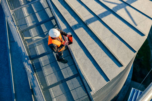 Top view of an industry worker standing on height and checking on silo supply. stock photo