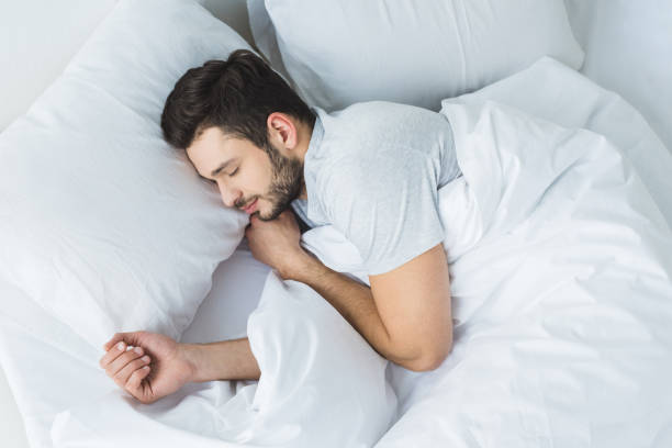 top view of bearded man sleeping on bed in bedroom top view of bearded man sleeping on bed in bedroom man sleeping in bed top view stock pictures, royalty-free photos & images