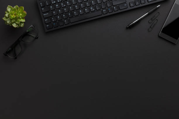 Top view of black office desk with computer and supplies stock photo