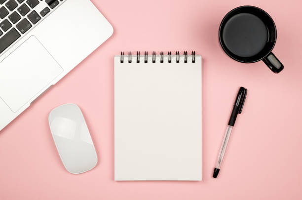 Top view of blank notebook page on pastel colored background office desk with different objects. Minimal flat lay style stock photo