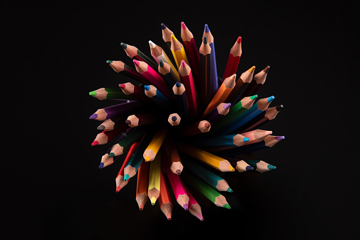 Top view of color pencils isolated on black background