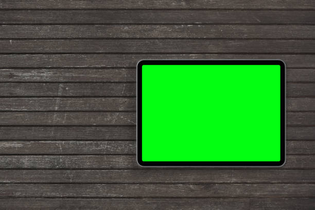 Top view of digital tablet computer with green isolated screen on wooden desk. Concept workplace. stock photo
