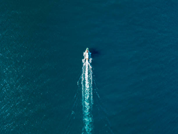 top view of fast travel boat going straight forward in the sea aerial shot - aerial boat imagens e fotografias de stock