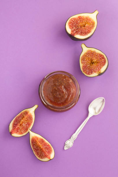 Top view of fig jam in the glass jar on the purple background stock photo