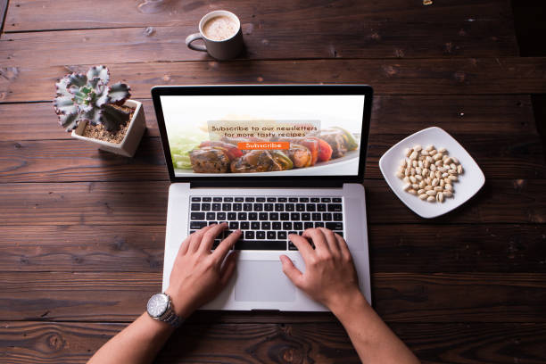 Top view of food blog subscription concept on the laptop / computer screen with wooden desk background stock photo