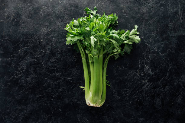 top view of fresh green celery on black marble surface top view of fresh green celery on black marble surface celery stock pictures, royalty-free photos & images