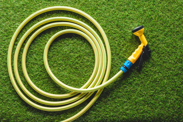 top view of hosepipe on grass, minimalistic conception top view of hosepipe on grass, minimalistic conception garden hose stock pictures, royalty-free photos & images