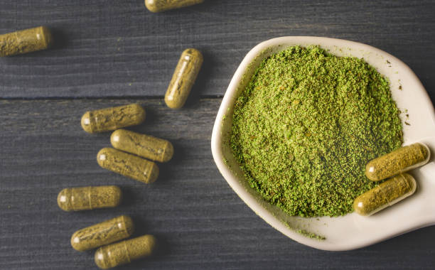 Top view of Kratom powder in ceramic spoon and Kratom capsules kratom stock pictures, royalty-free photos & images