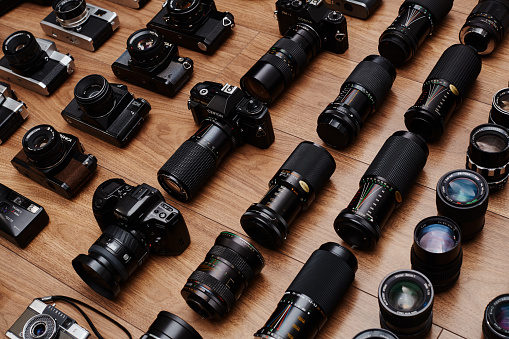 Top view of large group of analog vintage 35mm film cameras lying in arrangement close to each other