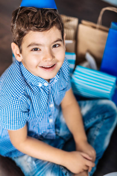 top view of little boy sitting on floor and smiling - foster home bag imagens e fotografias de stock