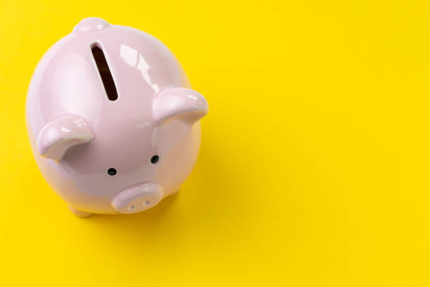 vista superior de la alcancía rosa en fondo amarillo vivo con espacio de copia, banca, presupuesto, gasto y concepto de ahorro - piggy bank fotografías e imágenes de stock
