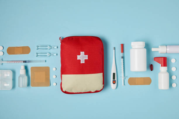 top view of red first aid kit bag on blue surface with medical supplies top view of red first aid kit bag on blue surface with medical supplies first aid stock pictures, royalty-free photos & images