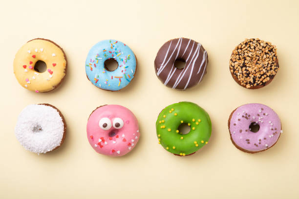 Top view of set of donuts on yellow background. Flat lay, copy space. Top view of set of donuts on yellow background. Flat lay, copy space. doughnut stock pictures, royalty-free photos & images