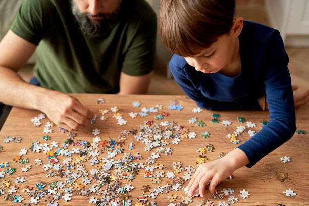 Top view of solving jigsaw puzzle on the table stock photo