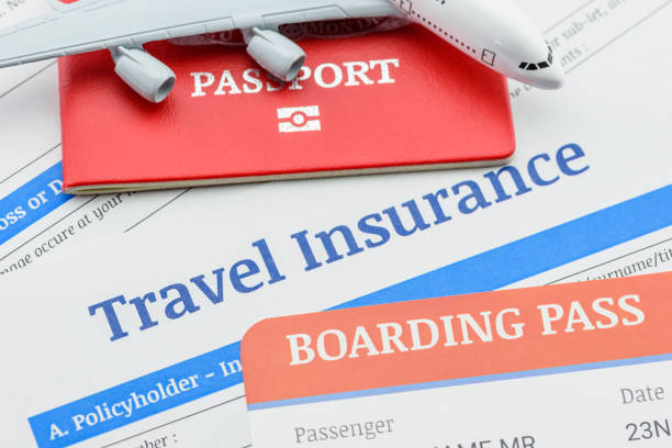 Top view of travel insurance application form, a boarding pass, a passport and an air plane. stock photo