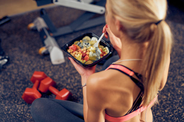 Top view of woman eating healthy food while sitting in a gym. stock photo